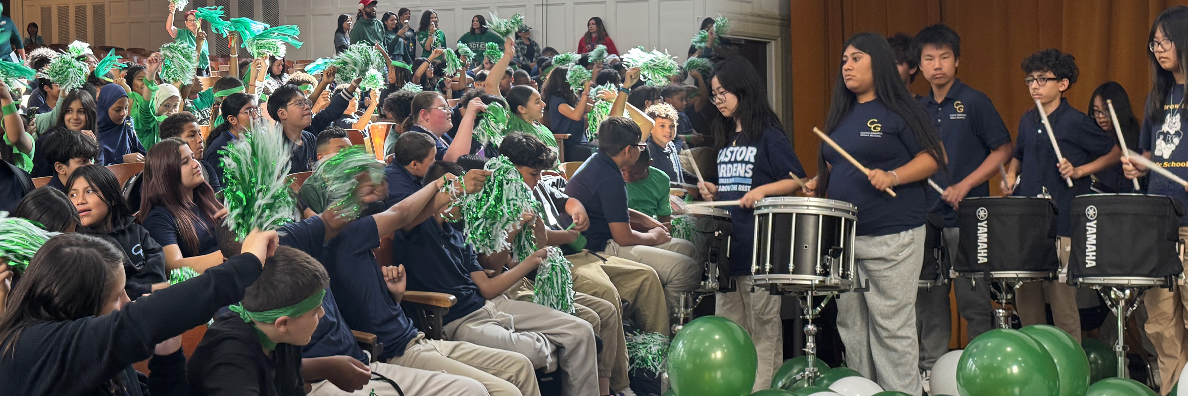 Students cheering with green and white pom-poms during a school assembly while the Castor Gardens drumline performs on stage.