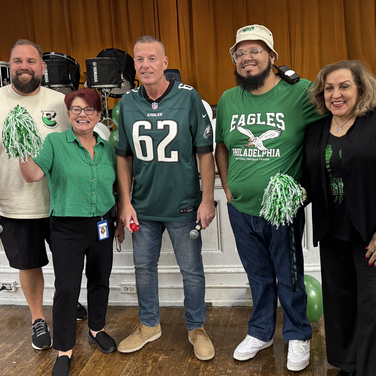 Principal and assistant principals of Castor Gardens Middle School standing together on stage during a school event.